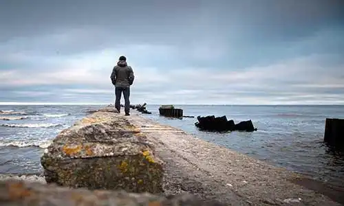 © eugenesergeev - Fotolia | A man on the old broken pier starring at the Sea