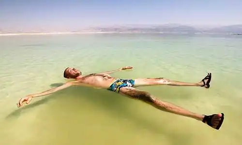 © toshket - Fotolia | A man rests his hand on the water of the dead sea in Israel