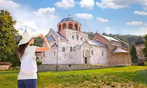 © Aleksandar Todorovic - Fotolia | Beautiful young woman in front of Monastery Studenica, Serbia.