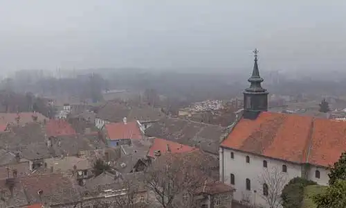 © lanalight - Fotolia | Novi Sad city roofs and church in fog